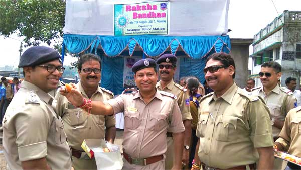 रक्षा बंधन उत्सव पर एसीपी को मिठाई खिलाते पुलिसकर्मी