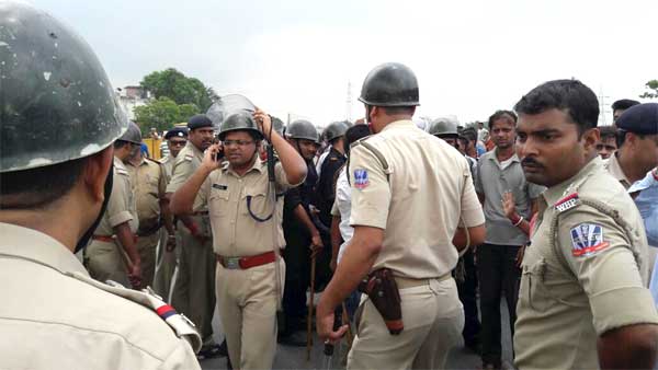 घटना स्थल पर भीड़ को संभालते चुनाव में तैनात पुलिसकर्मी 