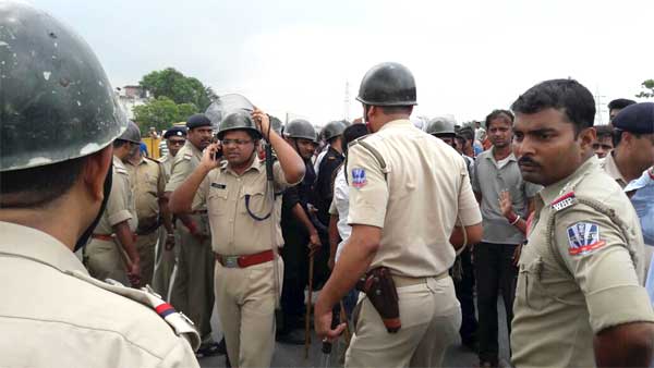 घटना स्थल पर भीड़ को संभालते चुनाव में तैनात पुलिसकर्मी