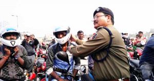 बिना हेलमेट बाइक चालक को हेलमेट वितरित करते तत्कालीन एसीपी ईस्ट बिमल मण्डल