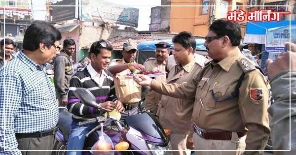 बिना हेलमेट के गाड़ी चलाने वाले चालक को फूल देते सलानपुर थाना प्रभारी । पुलिस के इस अप्रत्याशित रवैये से चकित व्यक्ति की खुशी देखी जा सकती है (फोटो : गुलजार खान )